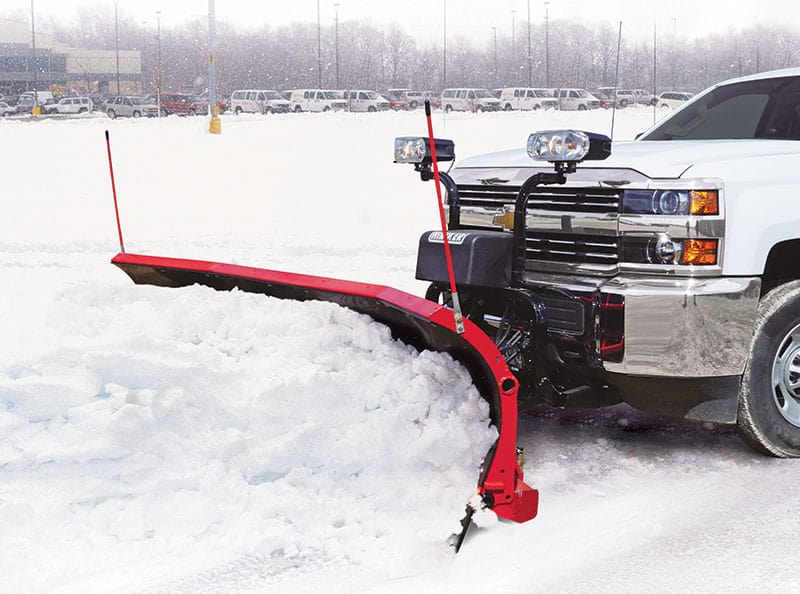 Hiniker Scoop Plow mounted on a truck pushing a pile of snow